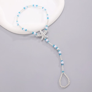 Detail of beaded star toe anklet with blue and white beads for beach vacations