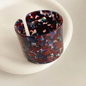 Close-up of vintage multi-color acetate open bangle with artistic spotted texture