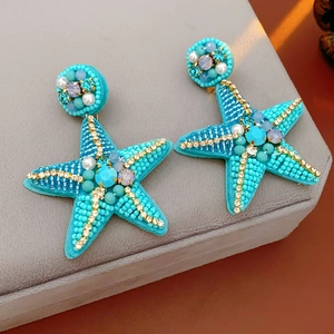 Macro detail of turquoise beaded starfish earrings with sparkling crystals and rhinestones