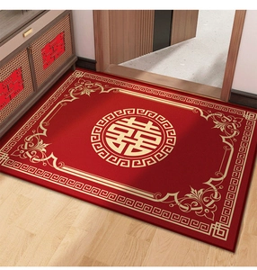 Detailed view of red wedding door mat with golden Xi character on wooden floor