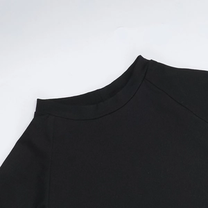 Dettaglio del girocollo nero e delle cuciture delle maniche raglan sul set in maglia