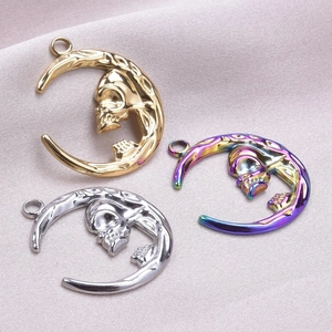 Three crescent moon skull pendants in gold, silver and rainbow stainless steel finishes