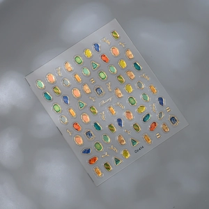 Macro shot of 3D nail stickers featuring colorful gems and gold embossed borders