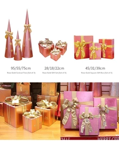 Dettaglio di scatole regalo di Natale oro rosa con fiocchi d'oro e addobbi ad albero