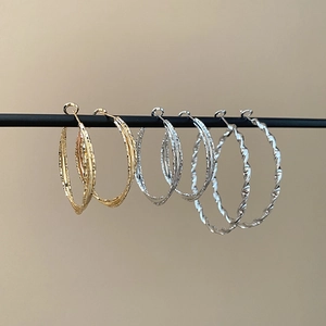Detailed set of gold and silver multi-layer and twisted geometric hoop earrings