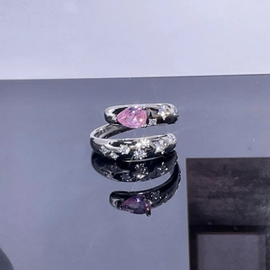 Detail of silver open ring featuring a pink teardrop stone and pavé micro-diamonds