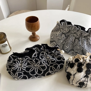 Detailed shot of lace clutch bags with embroidery patterns and pearl decorative charms