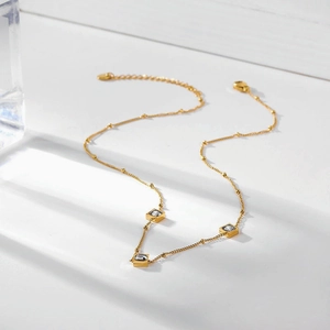 Titanium steel gold necklace with three square zircon gemstones on a white background