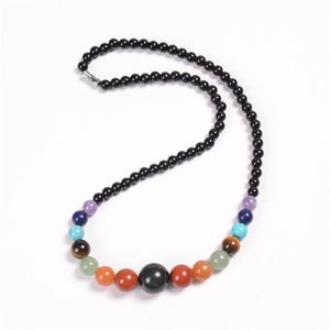 Macro detail of Bohemian beaded necklace with colorful natural gemstones on white background