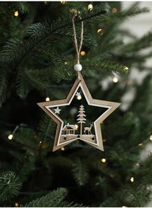 Detail of wooden star ornament with elk and forest laser cut design on Christmas tree
