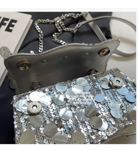 Detail of silver sequin bag showing double invisible magnetic buckles and chain strap