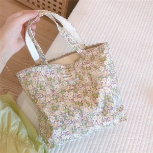 Détail d'un sac à main en coton à fleurs avec fermeture éclair et étiquette simple