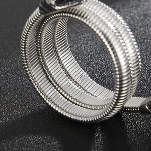 Macro detail of silver stainless steel snake bracelet showing fine threaded metal texture