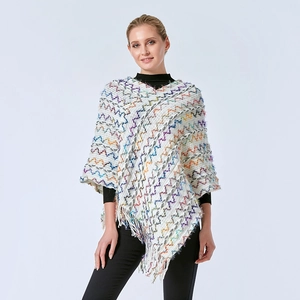 Détail du poncho en tricot à motifs géométriques colorés et bordures à franges