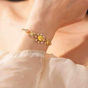 Details eines Vintage-Goldarmbands mit gelber Zirkonia-Blüte und Diamant-Akzenten