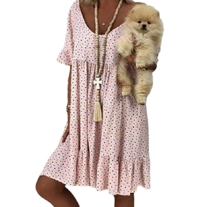 Detalle de vestido de verano rosa claro con lunares, mangas con volantes y falda a capas