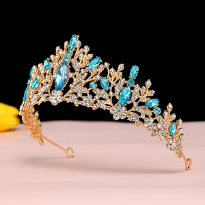 Macro detail of Baroque gold tiara with marquise-cut blue rhinestones and floral crystals