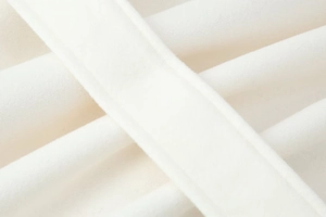 Close-up of premium white wool fabric texture and fine stitching on stylish coat
