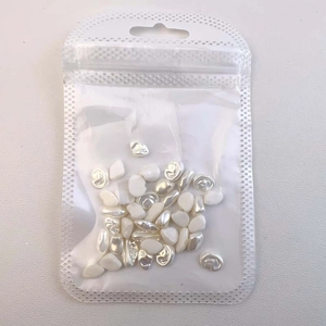 Detailed view of baroque pearl nail art charms in a transparent bag for manicure