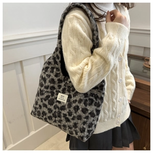 Detail of grey leopard print plush tote bag with high quality stitched woven brand label