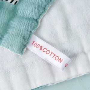 Close-up of 6-layer high density cotton gauze baby towel with 100% cotton material tag