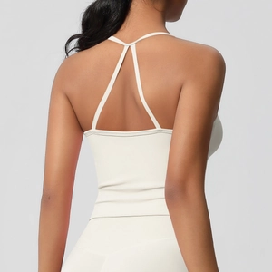 Dettaglio del top da yoga bianco crema con l'elegante design delle spalline a Y