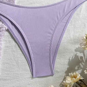 Macro detail of purple ribbed knit bikini bottoms with high elasticity texture