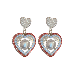 Boucles d'oreilles cœur vintage rouge avec perles synthétiques sur fond blanc pur