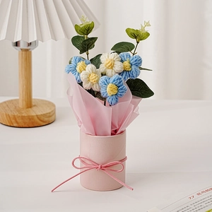 Handgemachter Häkelblumenstrauß mit fünf blau-weißen Puffblumen in einem rosa Eimer