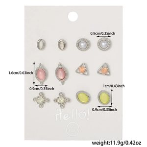 Close-up of a six-pair stud earring set with pearls and gemstones on a display card