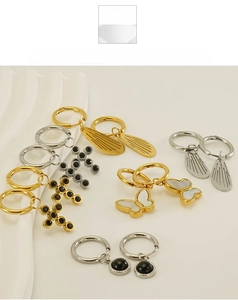 Macro detail of various stainless steel wing, butterfly and cross earrings in gold and silver