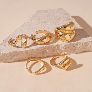 Detailed set of five minimalist gold irregular geometric rings with a fluid metallic finish