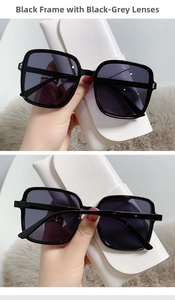 Close-up of square black sunglasses with gradient lenses and a white leather storage case
