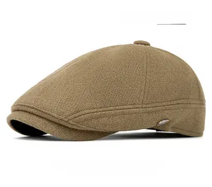 Detail of mugwort green wool beret featuring classic twill texture and metal button side