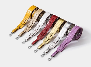 Close-up of adjustable crocodile-embossed leather straps with silver swivel hooks