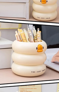 Close-up of yellow three-tier wave pencil holder with a cute duck mouth on desk