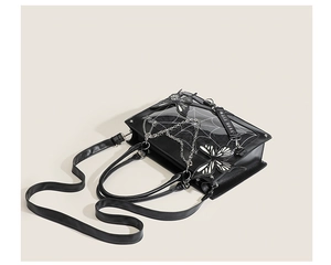 Detail of black PU leather gothic ita bag featuring white spider web print and butterfly appliques