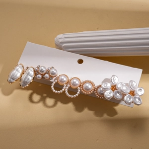 Detailed close-up of gold hairpin set with baroque pearls and elegant floral designs