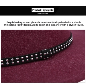Macro detail of wine red wool fedora with black velvet band and silver rivet studs