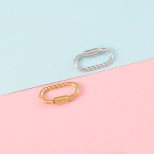 Detail view of oval gold and silver screw clasps on a colorful pastel background