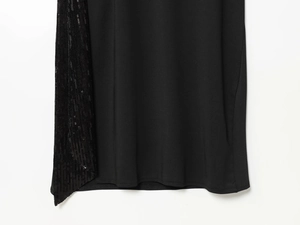 Gros plan sur le détail du patchwork à paillettes noires sur l'ourlet de la robe