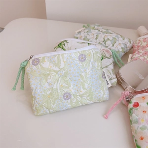 Close-up of assorted floral quilted cotton mini pouches with metal zippers and pull cords