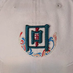 Detailed view of 3D Chinese embroidery and cloud patterns on a cotton baseball cap