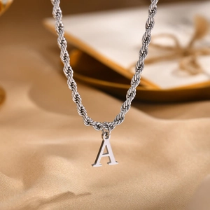 Macro shot of silver stainless steel twisted rope chain with polished letter A pendant