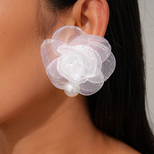 Boucle d'oreille fleur en tissu blanc avec perle et paillettes argentées sur mannequin