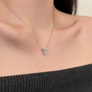 Detailed close-up of a silver bee pendant necklace with sparkling white zircons on collarbone
