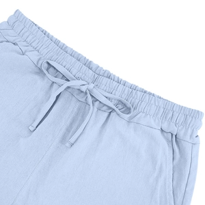 Detail of light blue linen shorts featuring elastic waistband with adjustable drawstring