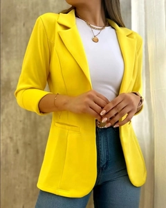 Detalle de una chaqueta entallada de mujer en color amarillo vibrante con corte informal