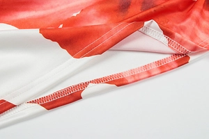 Detailed view of the hem stitching on white and red floral print summer dress fabric