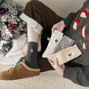 Détail montrant cinq paires de chaussettes de Noël en coton avec broderies de dessin animé